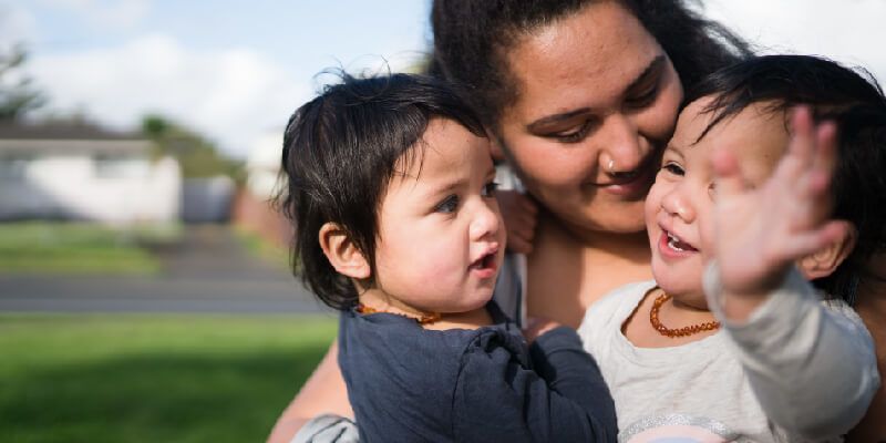 Mother holding two young children