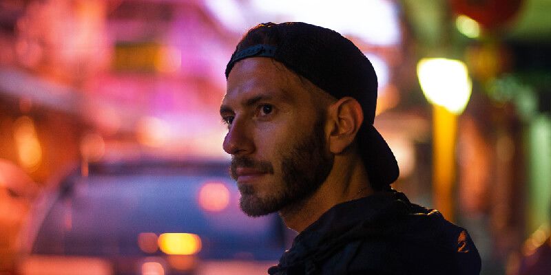 Young man standing on busy street at night