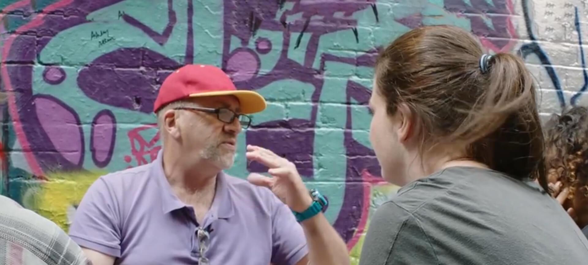 Man and girl in front of graffiti wall