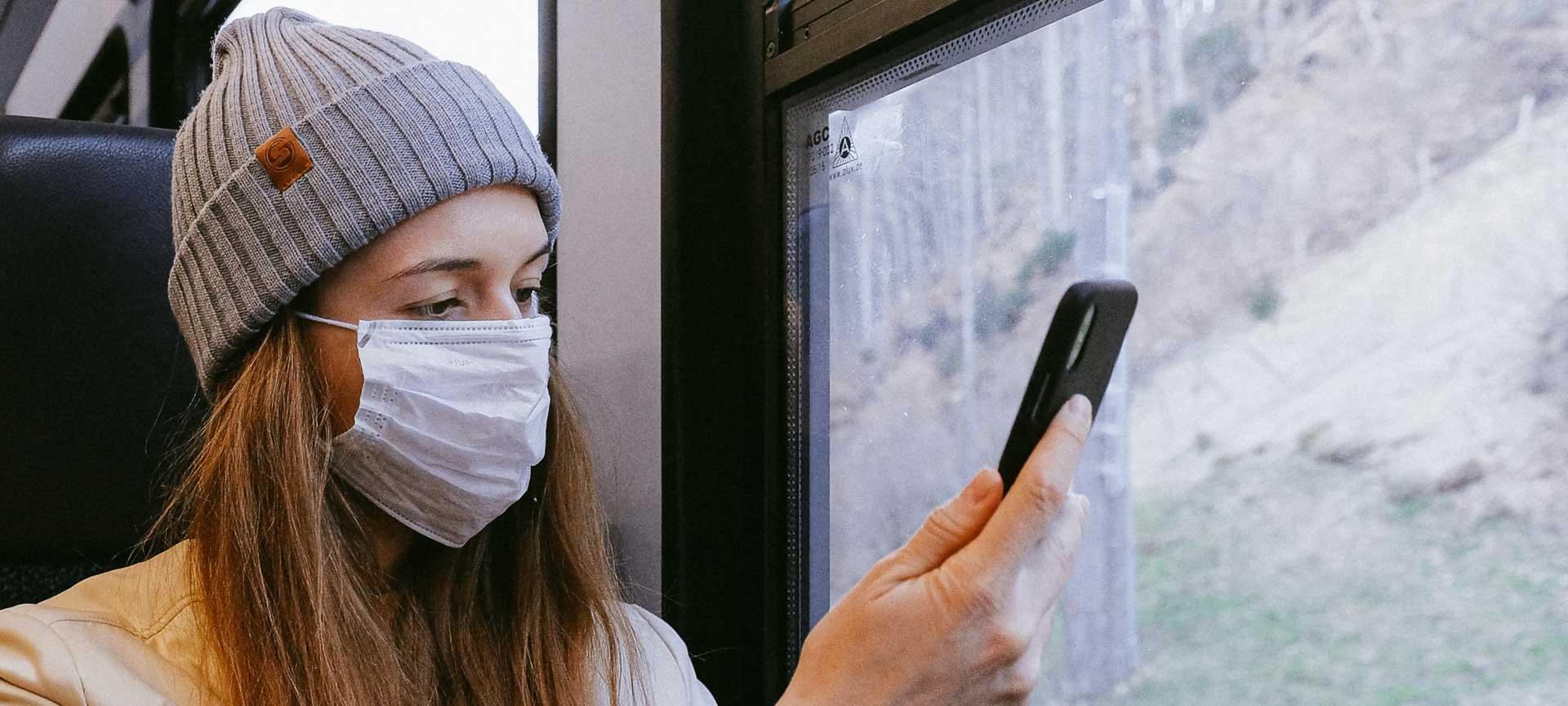 Woman wearing face mask using phone