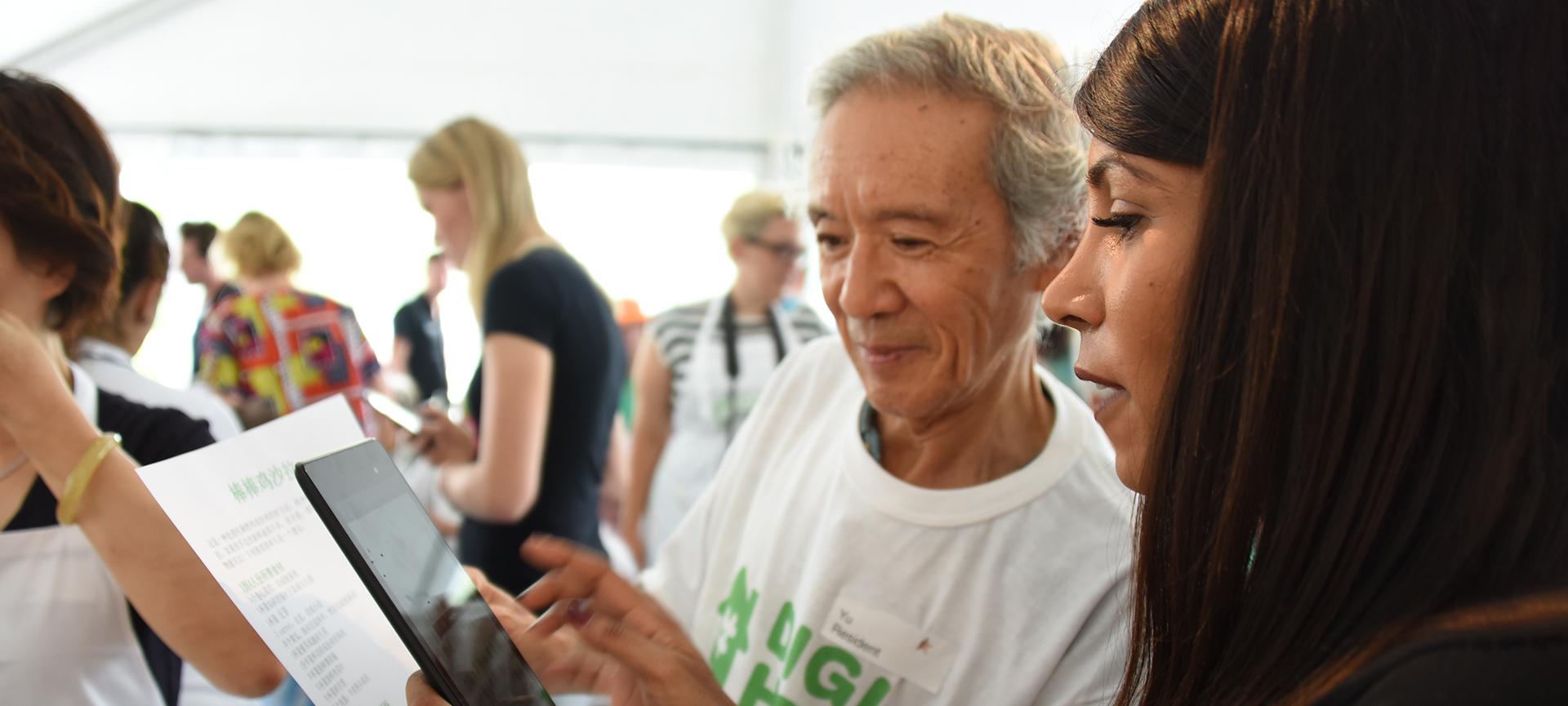 Older man and young woman looking at phone