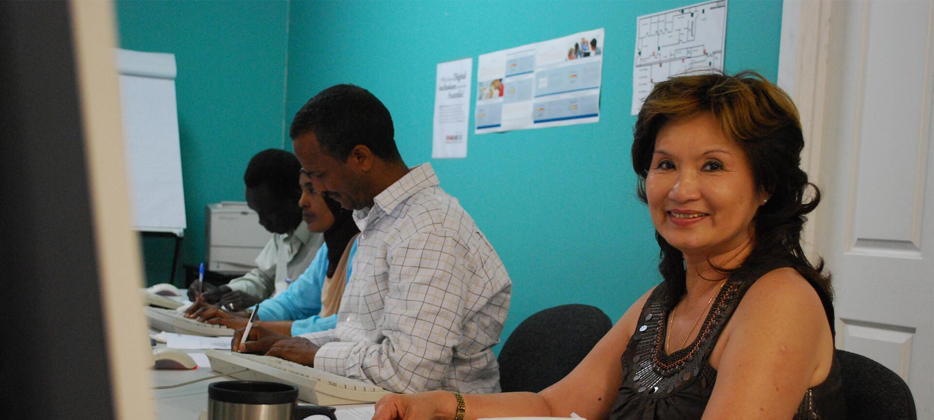 Woman smiling with people using computers