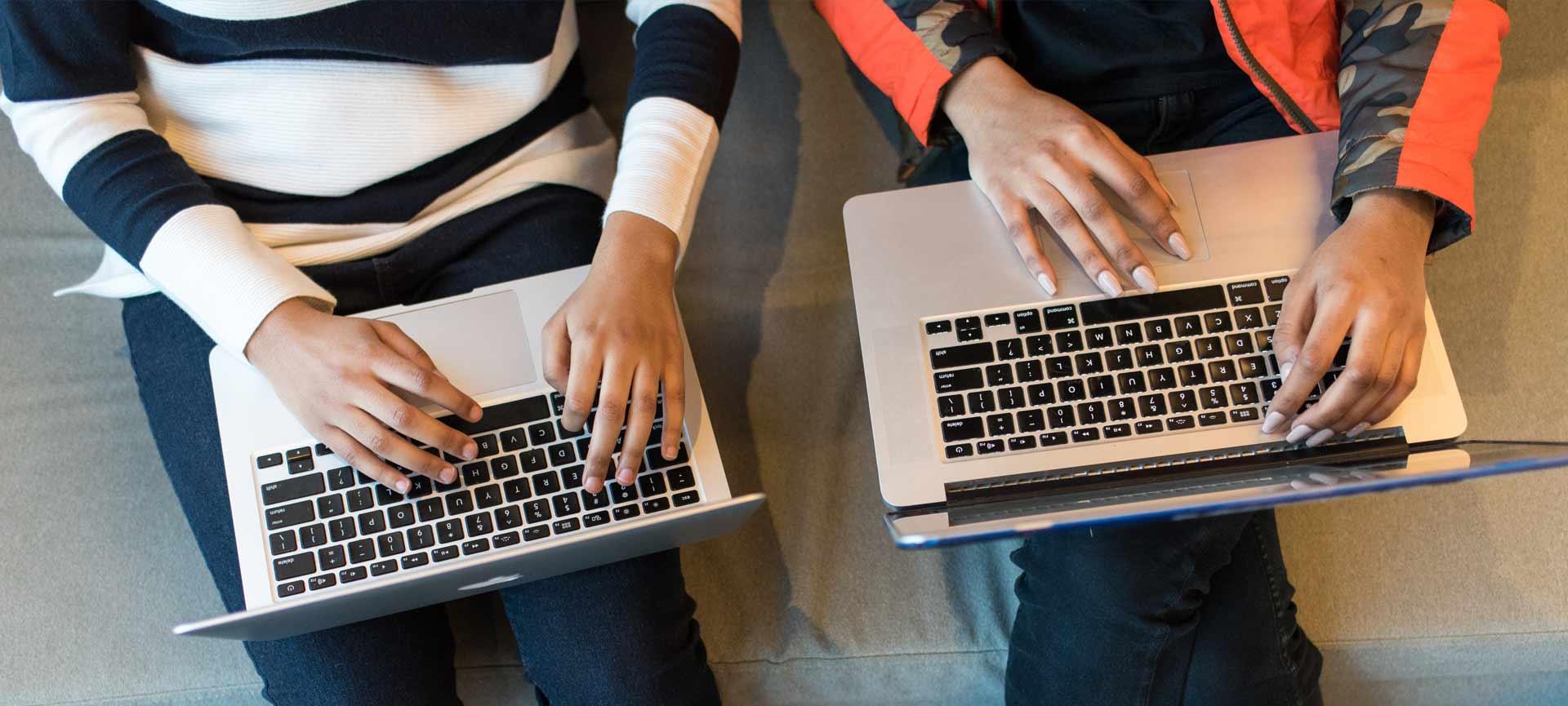 Two women using laptops