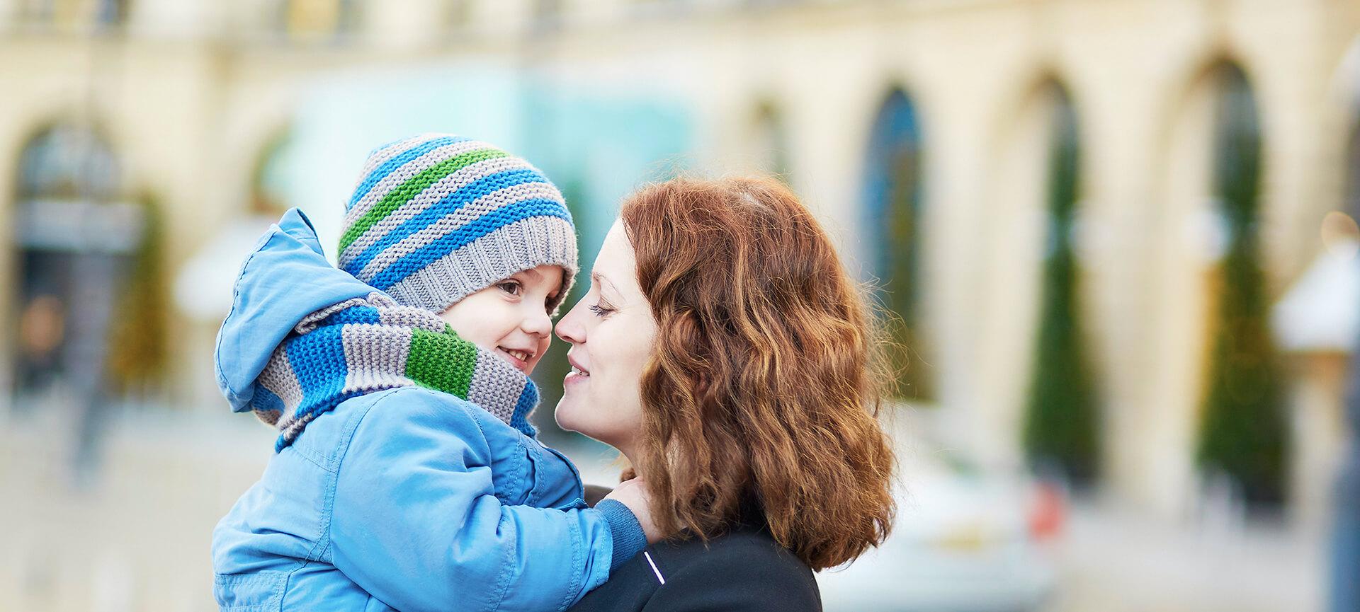 Woman holding son outside