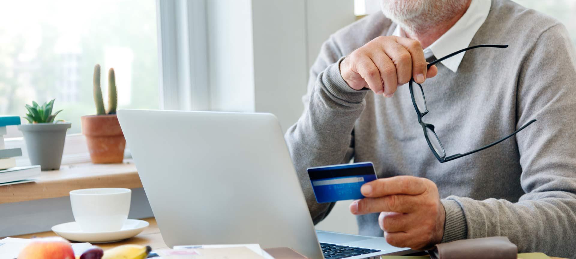 Older man using credit card for online shopping