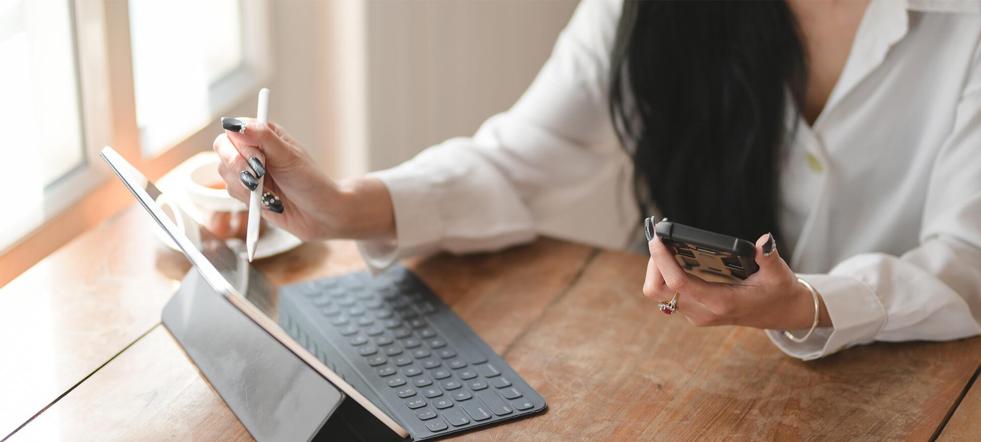 Woman working from home with tablet and phone