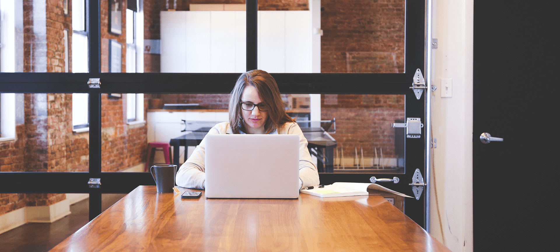 Woman with laptop at large table