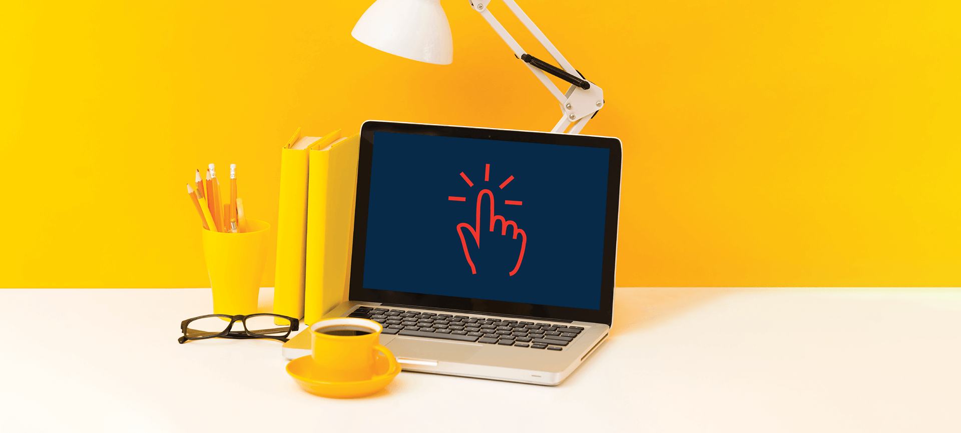 Laptop on desk with bright yellow background