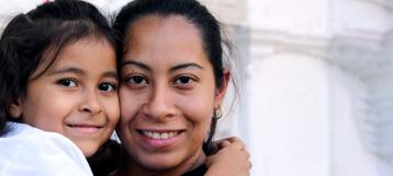 Woman holding her daughter smiling