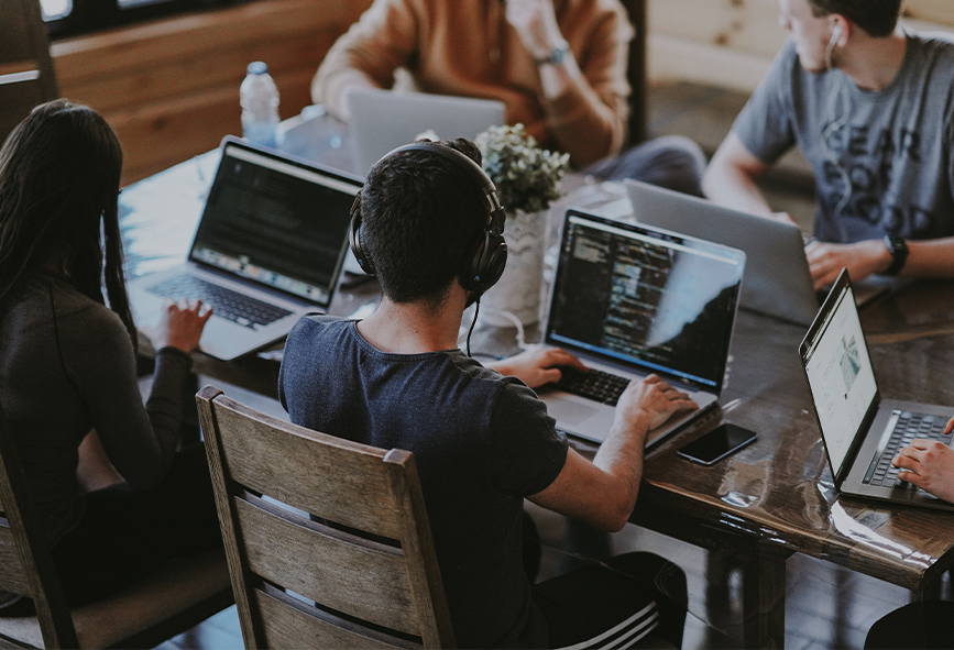 Group of people with laptops sitting around a table
