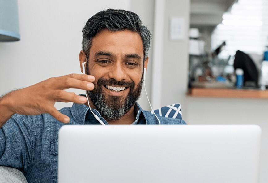 Man at home talking on a video call on his laptop