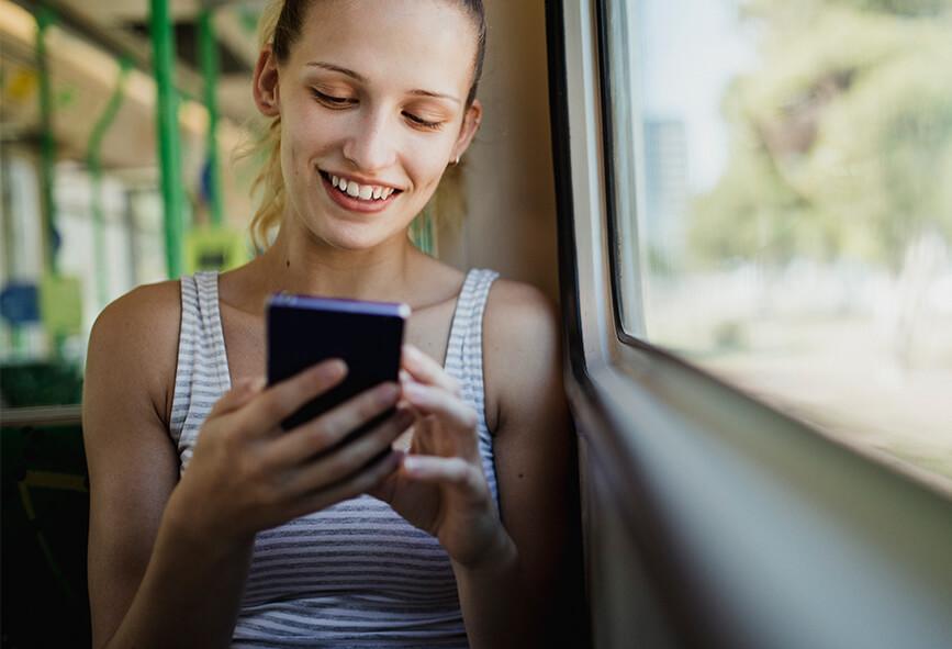 Woman using phone on tram in Melbourne