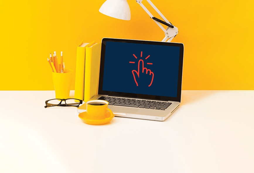 Laptop on desk with bright yellow background